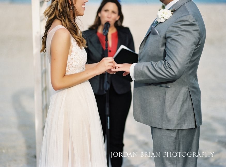 Bride and groom exchange rings at outdoor beach wedding ceremony in Avalon, NJ.
