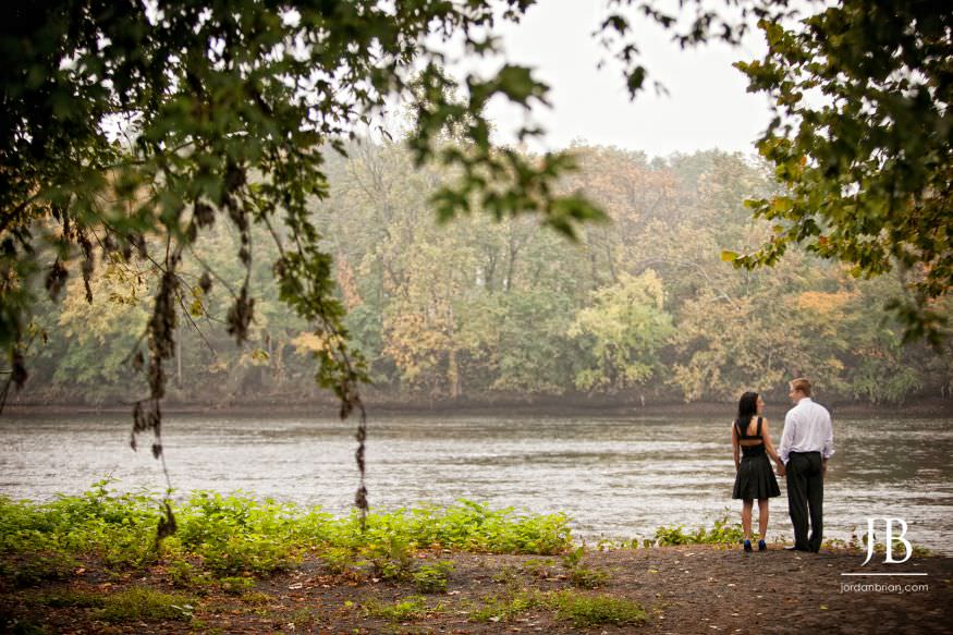 Couple walking along the Raritan River at Rutgers New Brunswick engagement session
