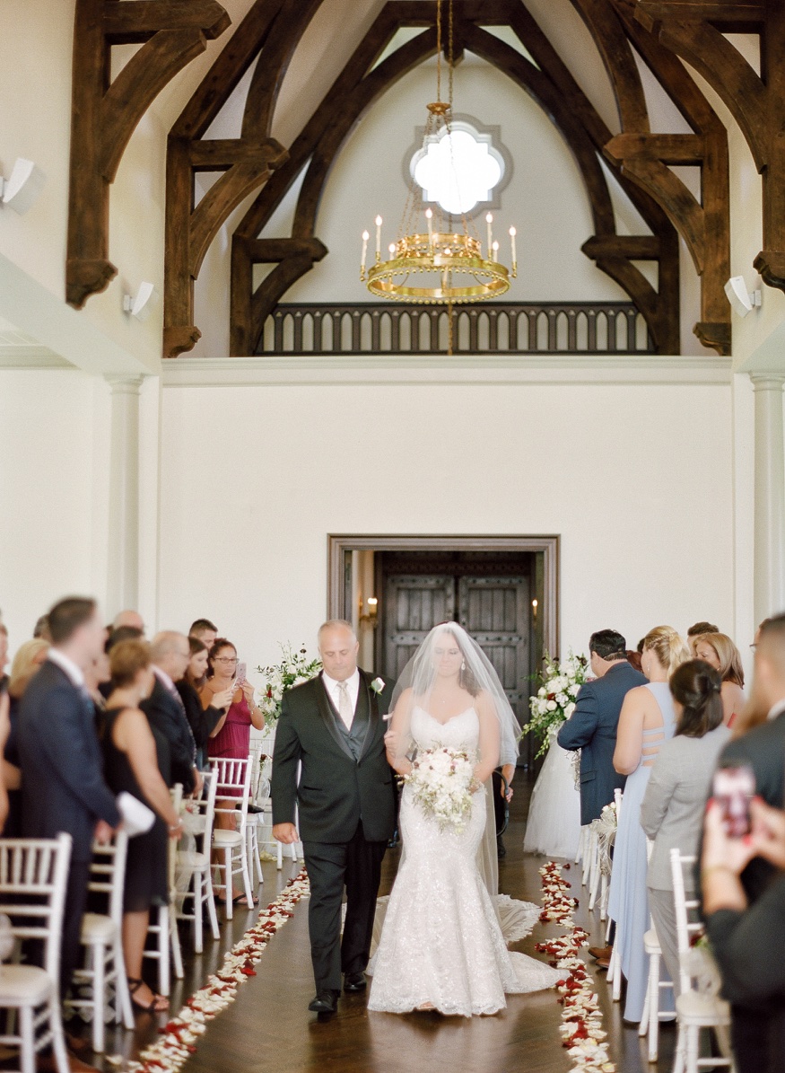 Bride and father walk down the aisle at the Park Chateau wedding ceremony.