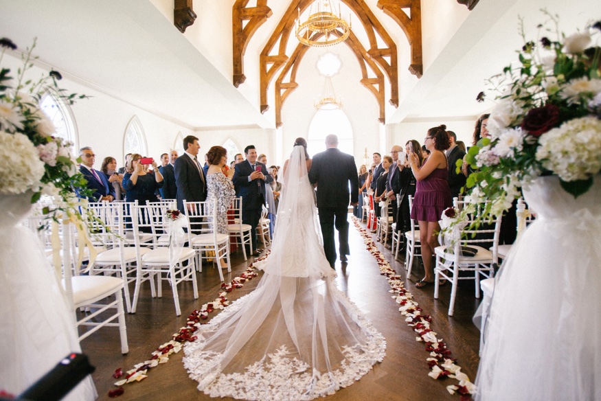 Bride and father walk down the aisle at the Park Chateau wedding ceremony.