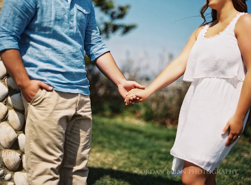 couple holding hands at long branch beach engagement session