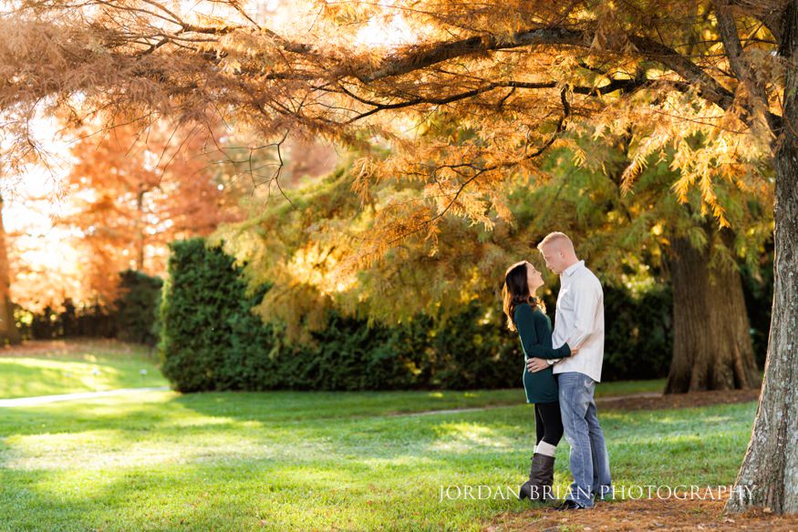 Christina and Brandon walking alongside the Longwood Gardens pond during fall engagement session