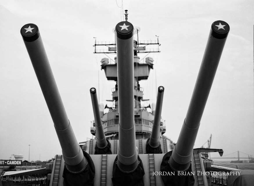 Summer engagement portrait of Denise and Tom on the deck of the USS New Jersey