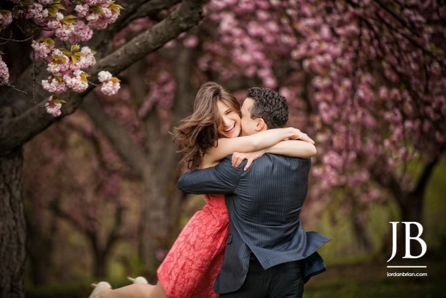 please touch museum engagement session couple hugging with cherry blossoms