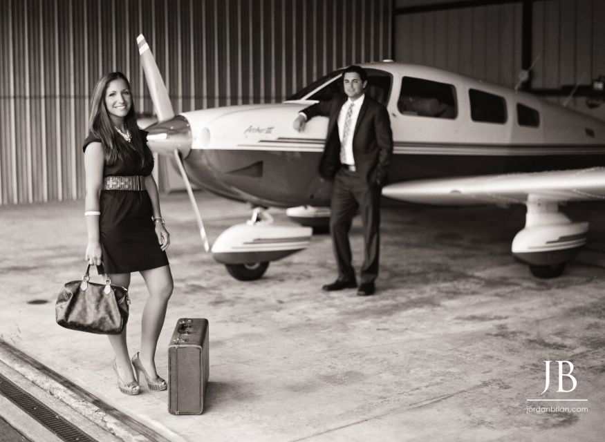 Gina and Steve laughing together during engagement session at South Jersey vintage airshow hangar