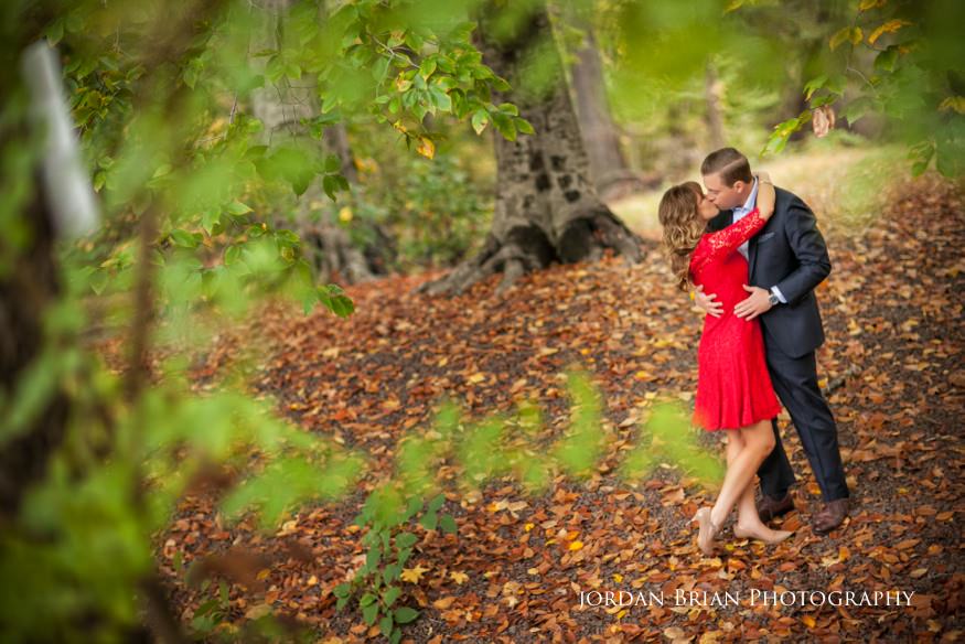 Chris and Holly walking together through autumn woods in Medford