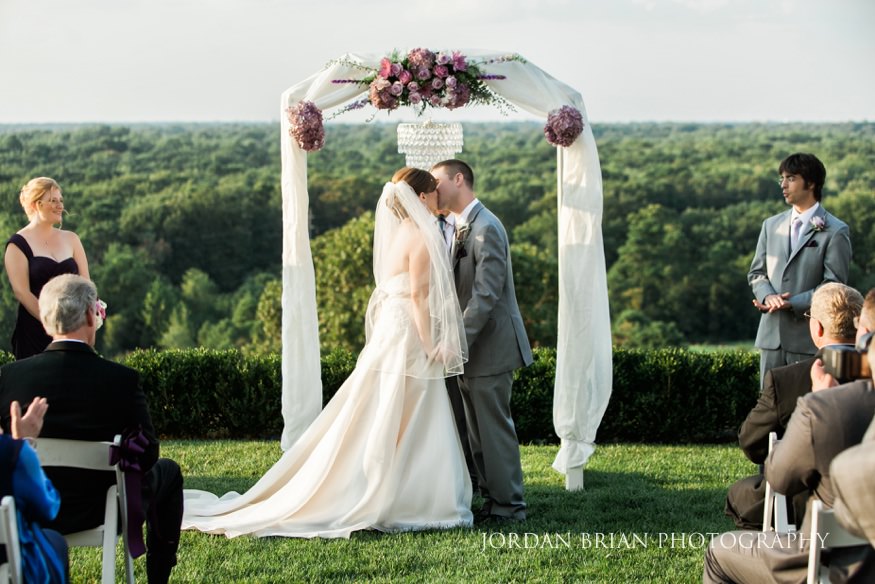 Bride and groom kiss at Trump National outdoor wedding ceremony.