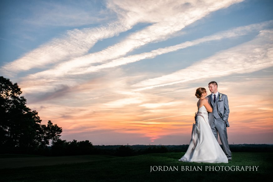 Bride and groom in front of sunset at Trump National wedding.
