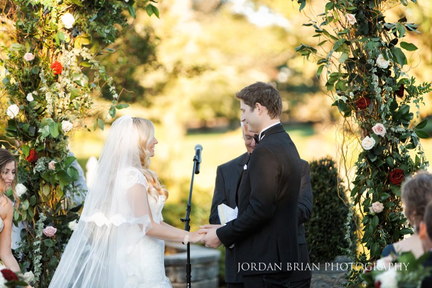 Bride and groom exchanging rings at outdoor ceremony at Windows on the Water Frogbridge wedding.