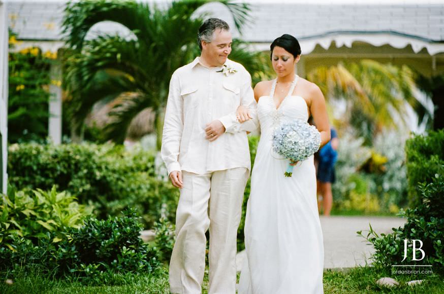 Father looking at Laurie while walking her down the aisle, Jamaica destination wedding