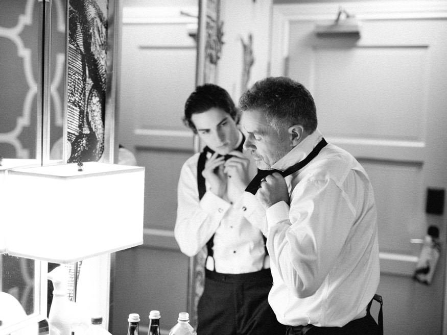 Greg checking his tie in the mirror at Hotel Monaco before the Museum of the American Revolution wedding.