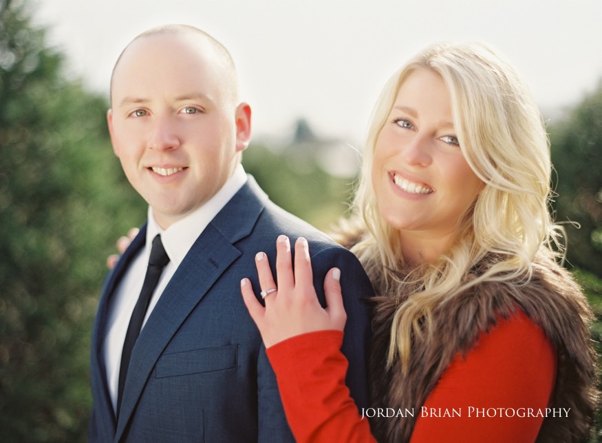 Megan and Kevin walking hand in hand through the Christmas tree farm during their South Jersey engagement session