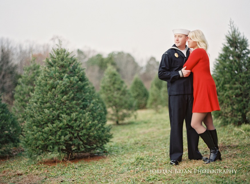 Megan and Kevin in Navy uniform and wedding dress pose at the Christmas tree farm