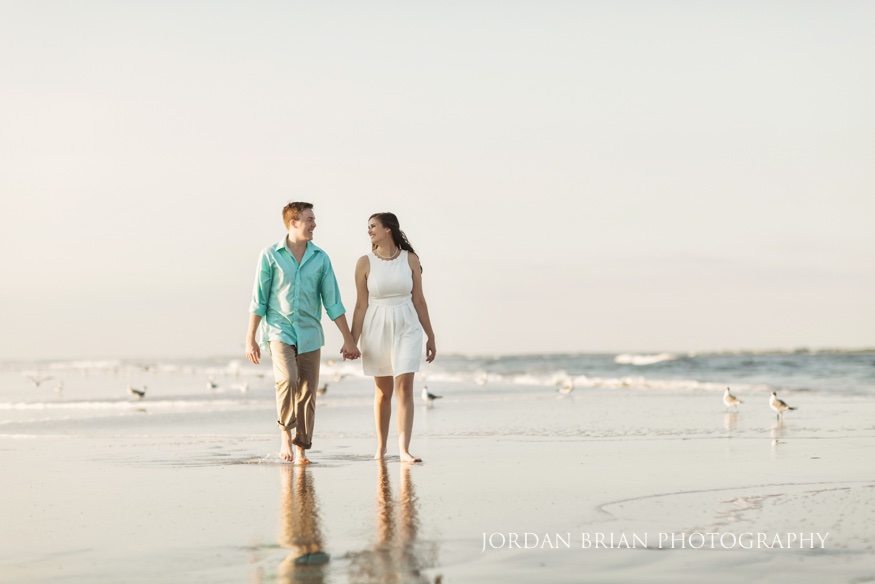 Rebecca and Mat walking the shoreline at golden hour during Wildwood engagement