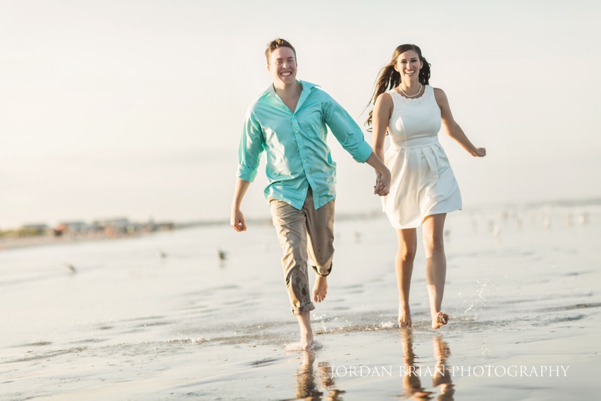 Rebecca and Mat running along the Wildwood beach during their engagement session