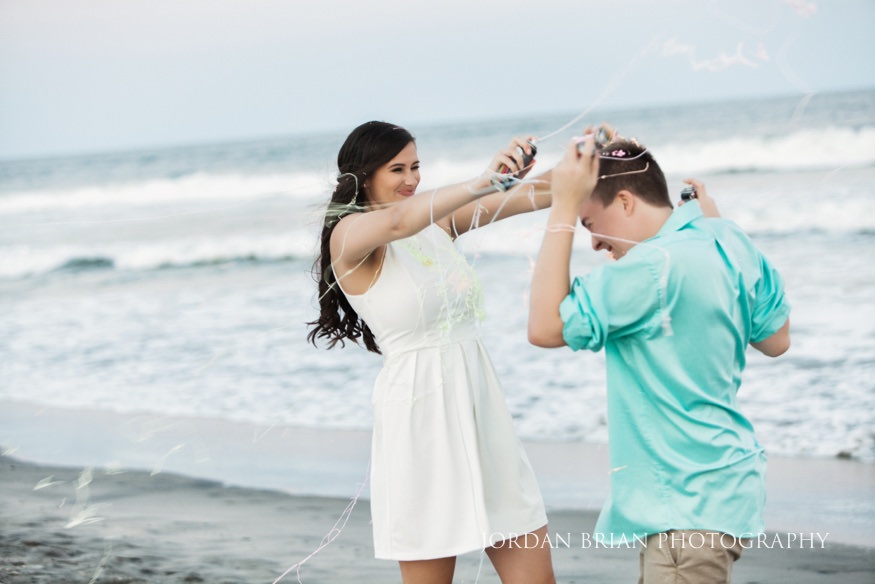Couple spray eachother with silly string at Wildwood Engagement session.