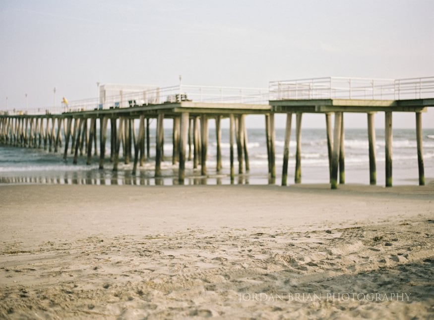 Simona and Brandon champagne toast on the blanket during Ventnor beach engagement portraits