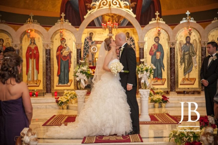 Stasia and Evan during the Greek Orthodox wedding ceremony, ornate church backdrop