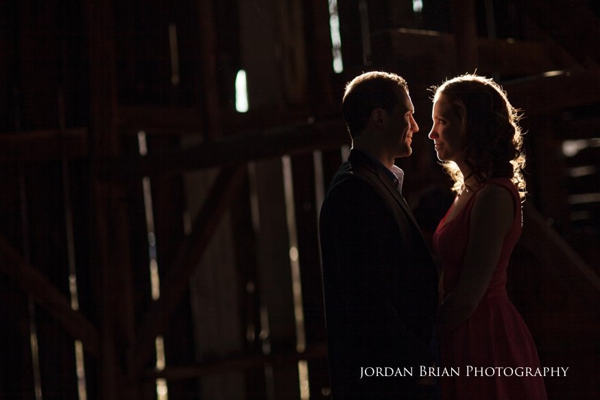 Tara and Paul reflected in the rain pooled near the old barn