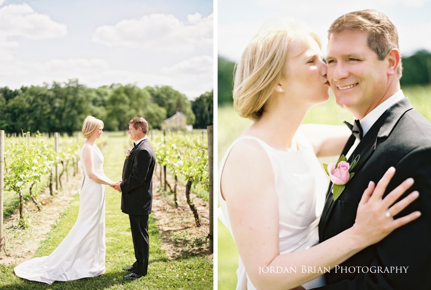 Bride and groom kiss between the vines at Valenzano Winery