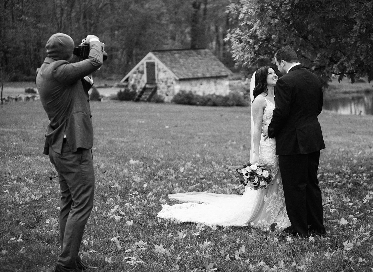 Black and white behind-the-scenes shot of Jordan photographing a couple on their wedding day