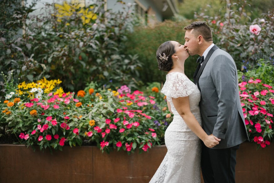 Bride and groom kiss in flower garden Valley Green Inn