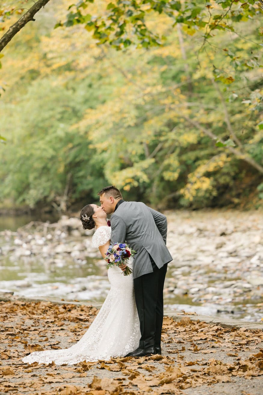 Romantic kiss along Wissahickon Creek Valley Green Inn wedding
