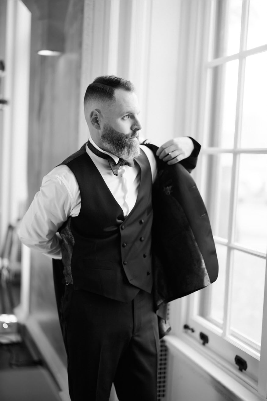 Groom adjusting tie at Curtis Arboretum wedding