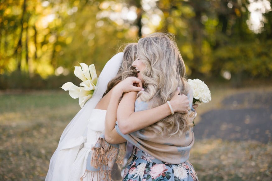 Bride hugging bridesmaid after ceremony Curtis Arboretum