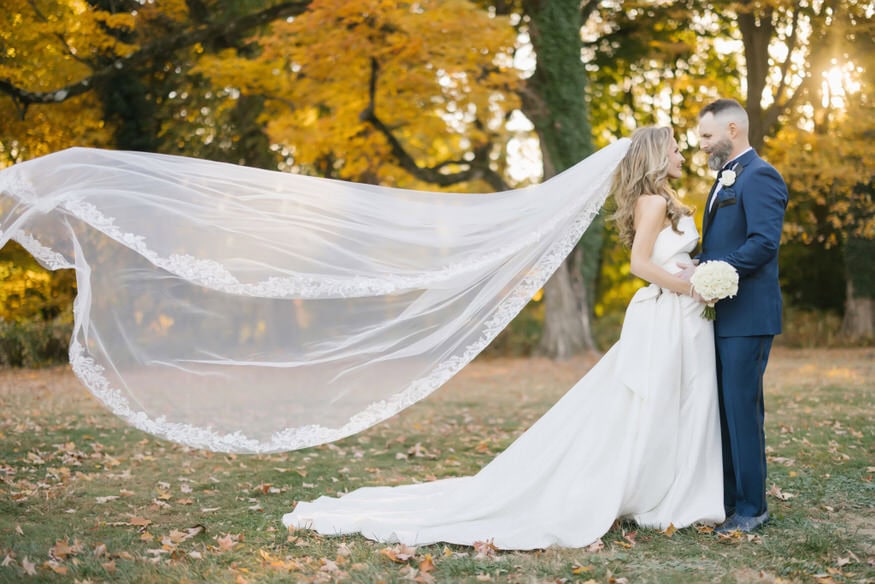 Couple walking through autumn leaves Curtis Arboretum wedding