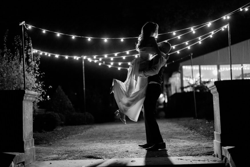 Groom lifts bride nighttime portrait Curtis Arboretum