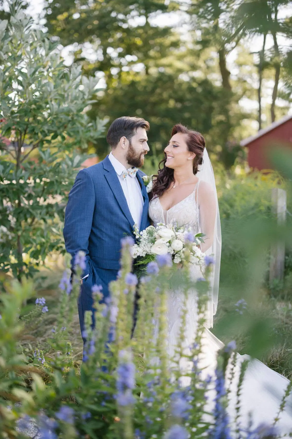 Bishop Farmstead Wedding couple portrait with flowers next to barn