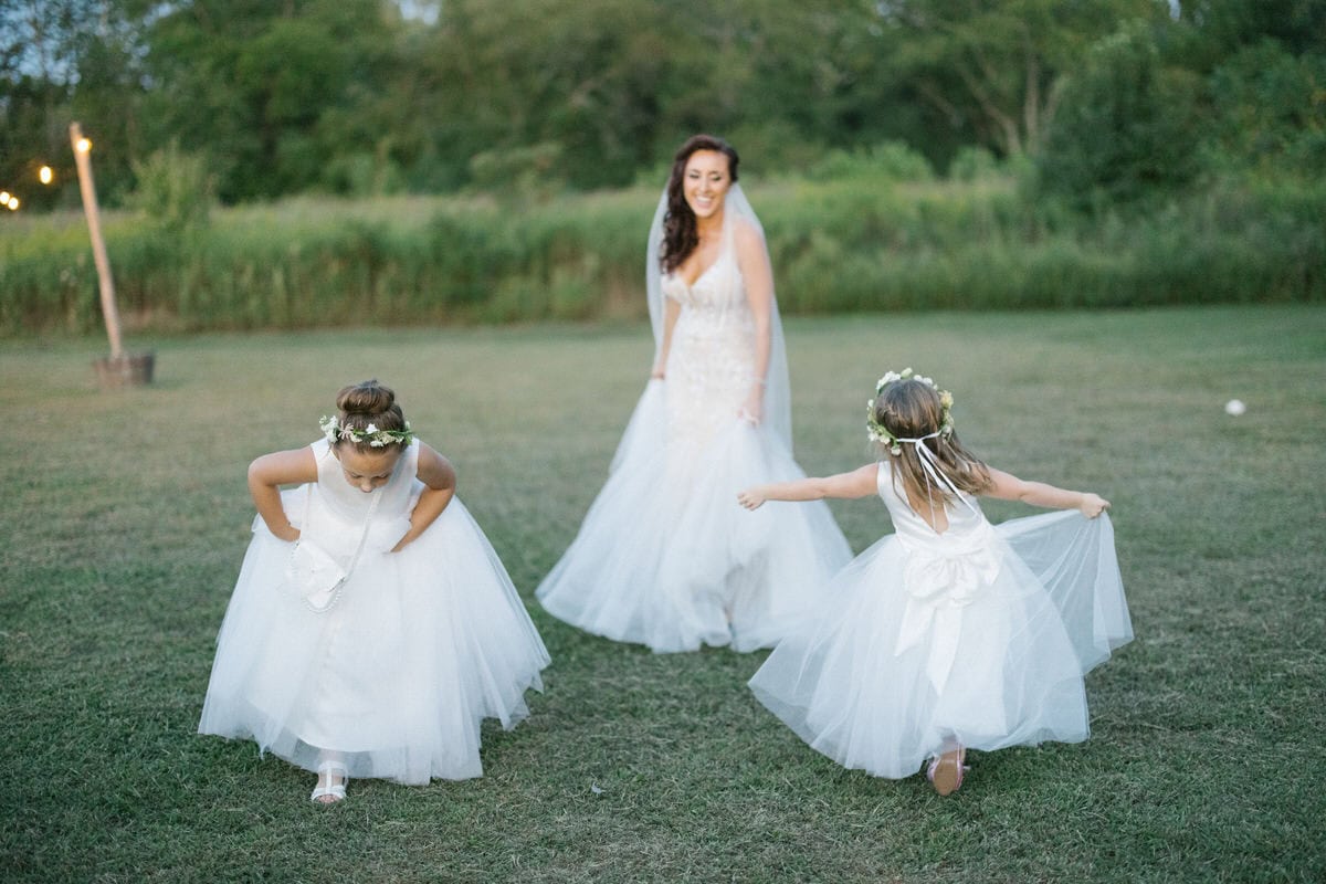 Bishop Farmstead Wedding cocktail hour bride playing with flower girls