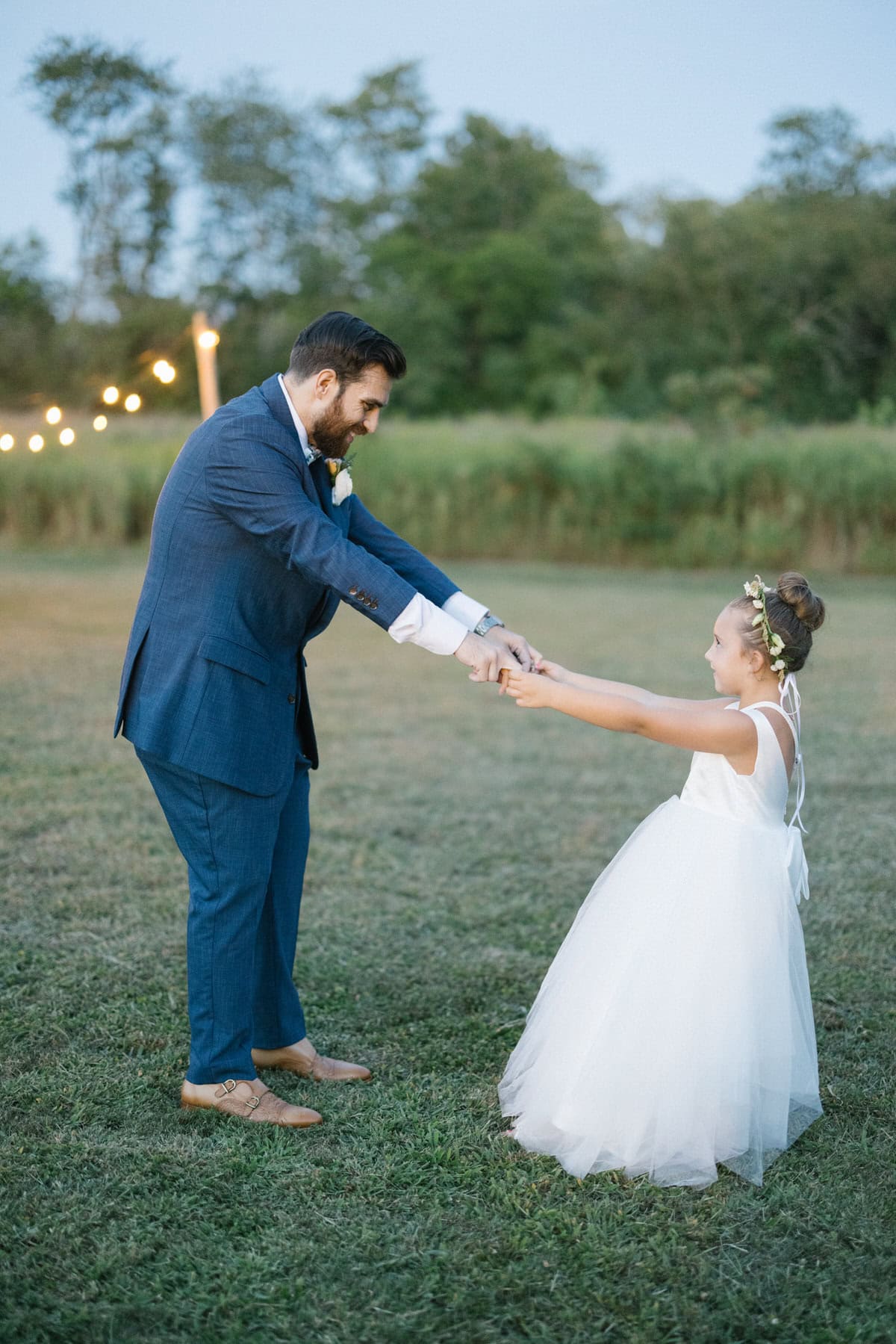 Bishop Farmstead Wedding groom dancing with flower girl outside during cocktail hour