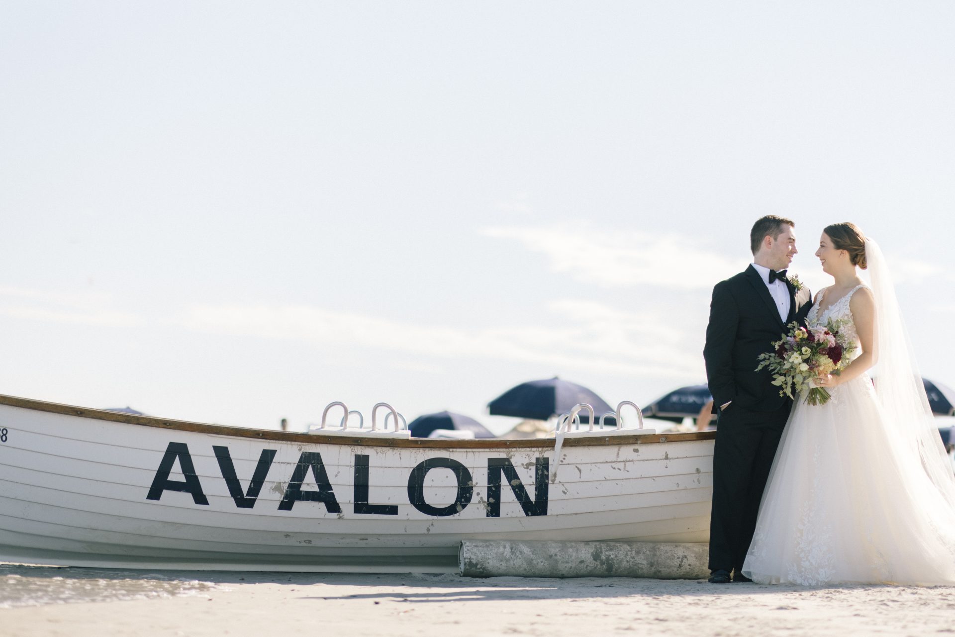 Couple on the beach at ICONA Avalon with the iconic Avalon rescue boat backdrop, Avalon NJ