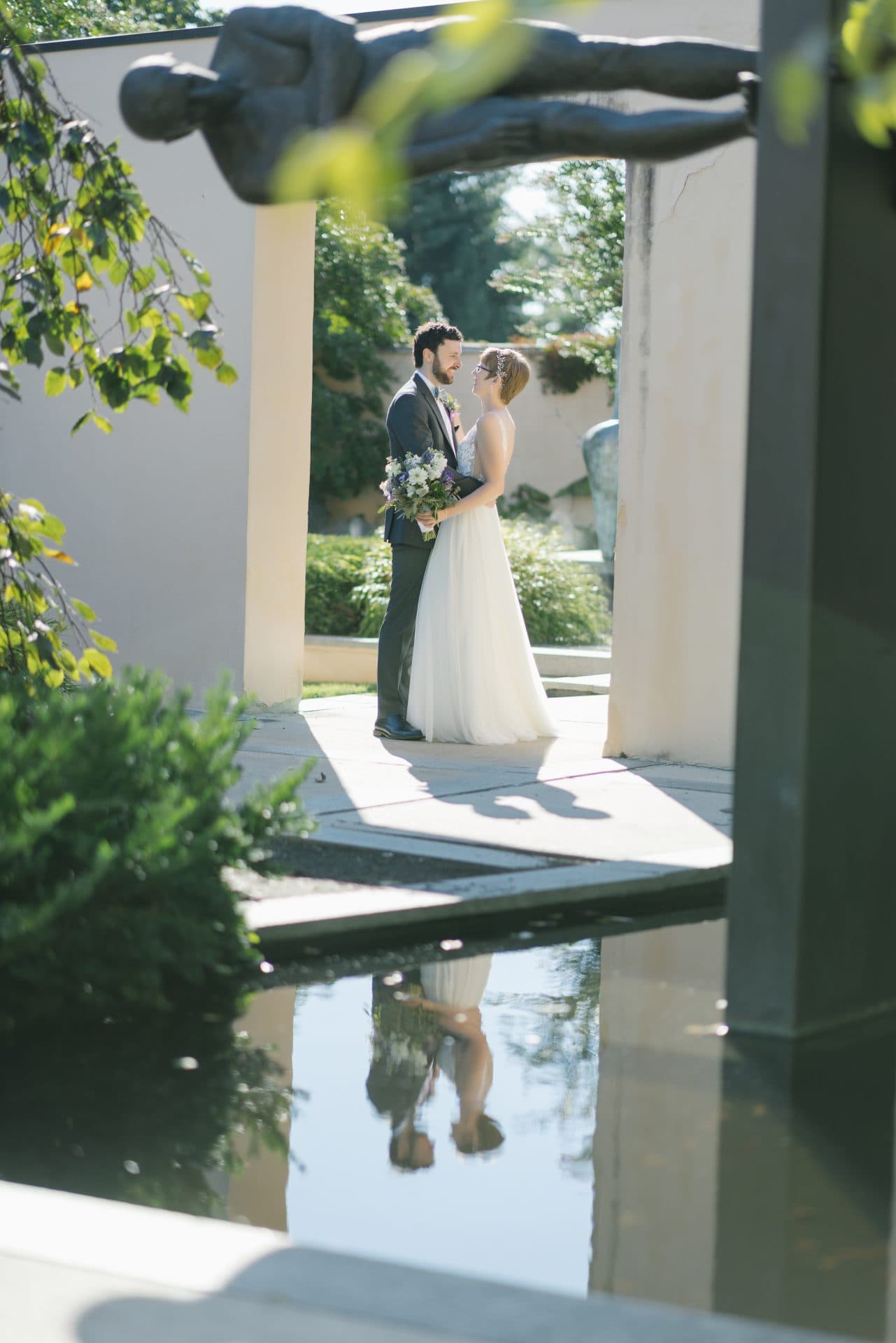 Couple portrait in The Water Garden framed by columns with reflection pool at Grounds for Sculpture in Hamilton NJ