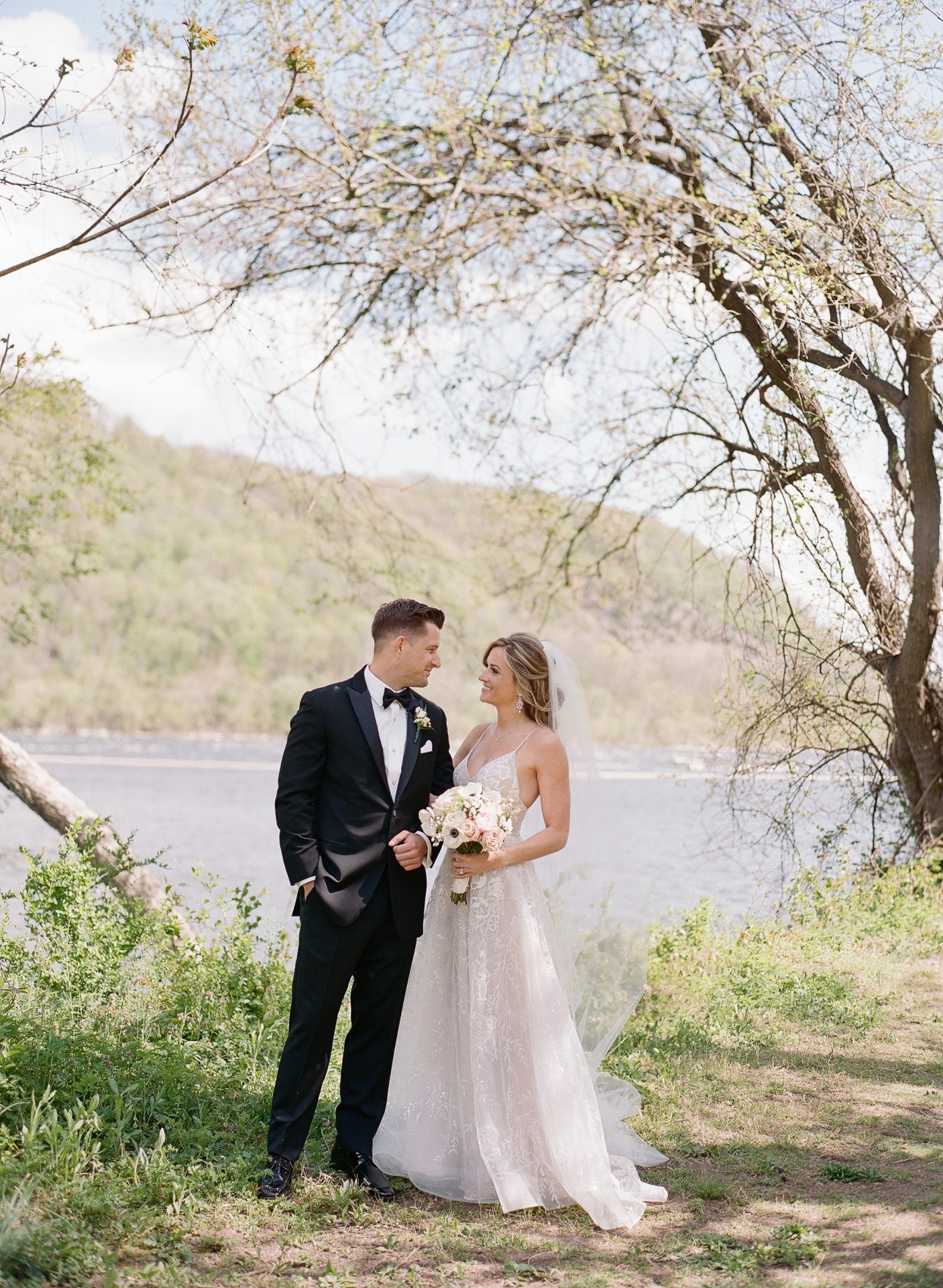 Couple portrait by the Delaware River with hills at River House at Odette's in New Hope PA