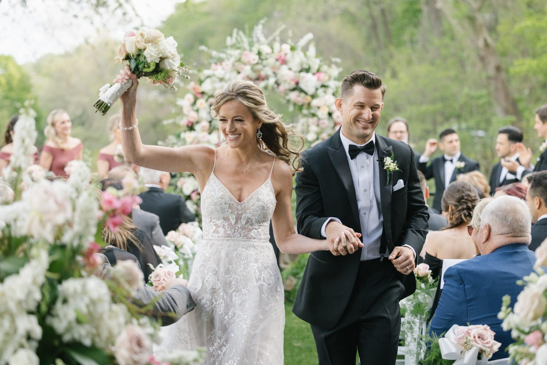 Wedding recessional with floral arch and joy at River House at Odette's in New Hope PA