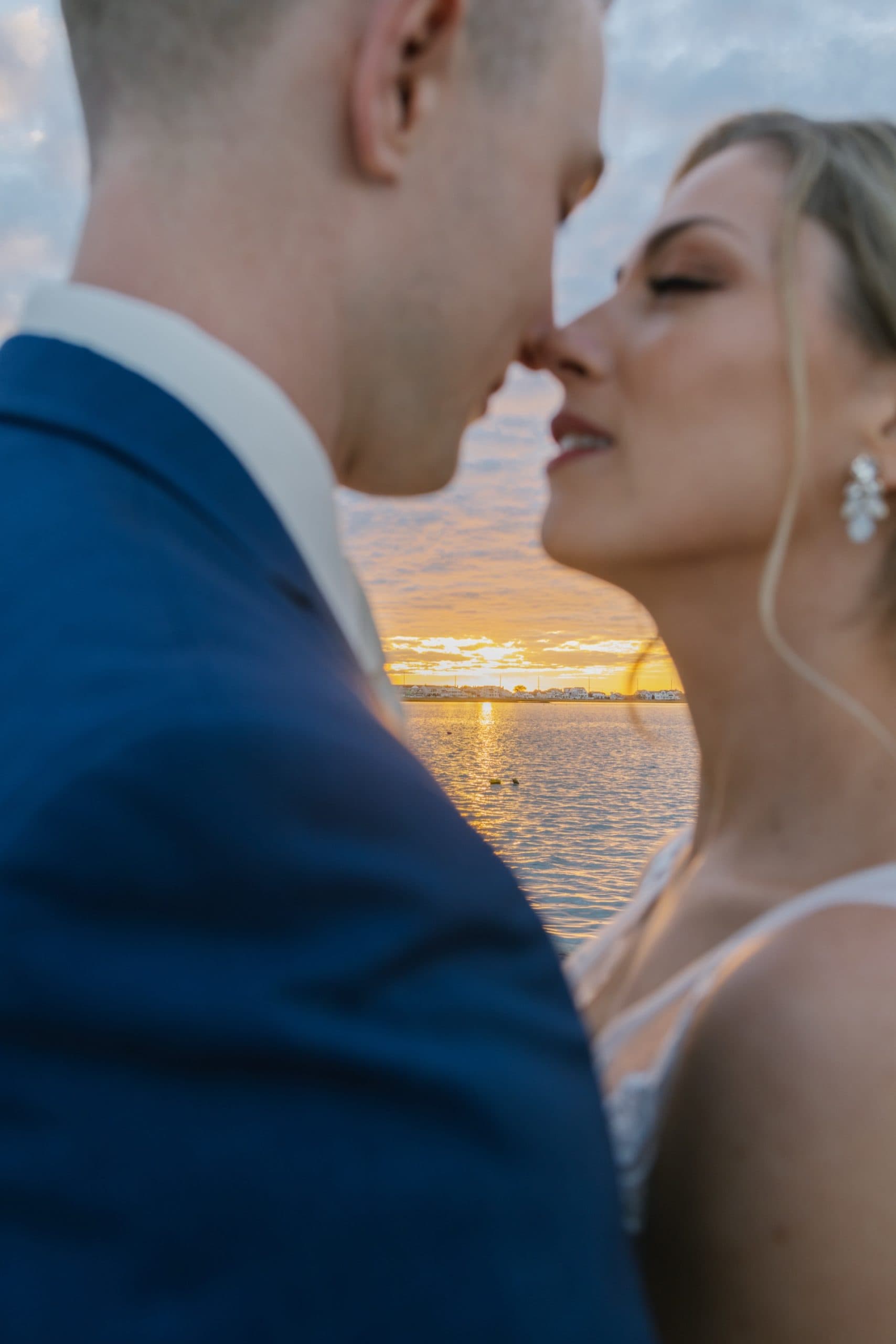 Dramatic bay sunset colors behind couple on the dock at ICONA Avalon, Avalon NJ