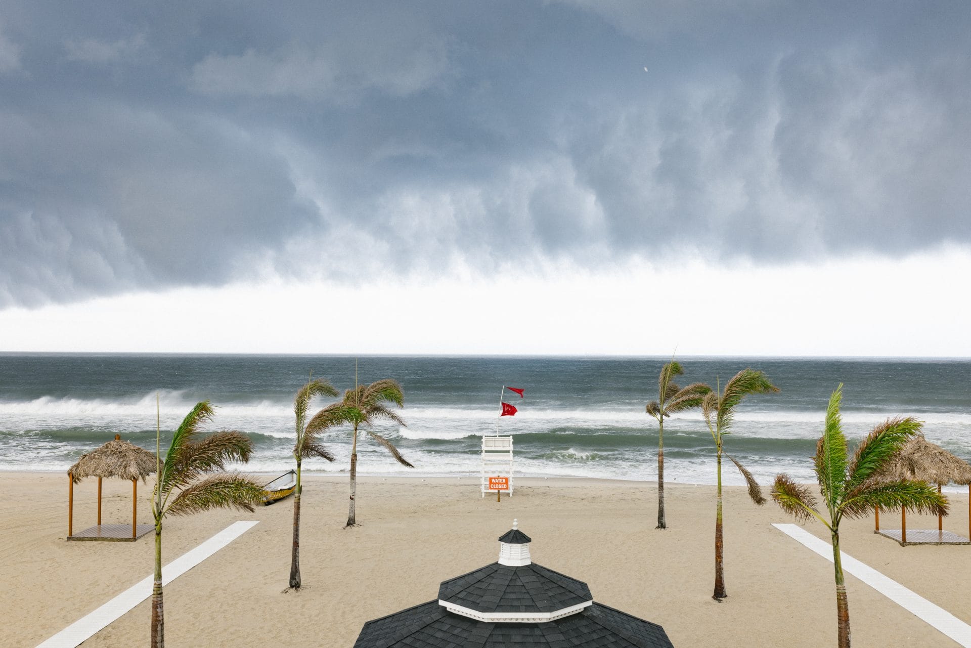 Dramatic storm clouds over the beach with palm trees bending in the wind at Windows on the Water, Sea Bright NJ