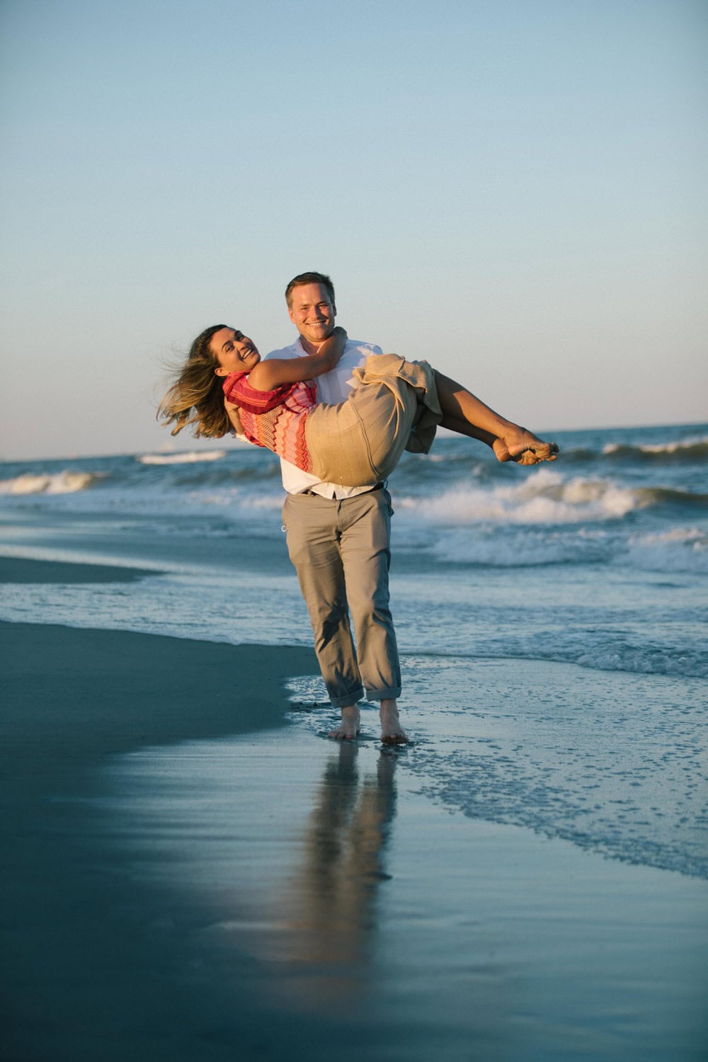 Jersey Shore surprise proposal - groom carrying bride on beach at sunset