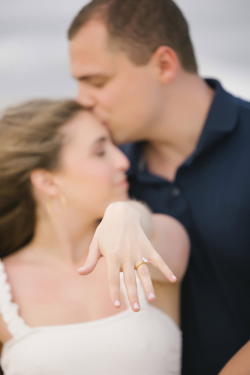 LBI engagement mini session - ring detail with couple kissing on beach