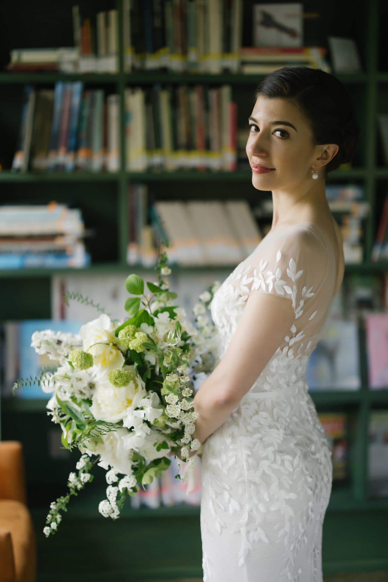 Bride getting ready with bookshelves in The Library at Grounds for Sculpture wedding venue, Hamilton NJ