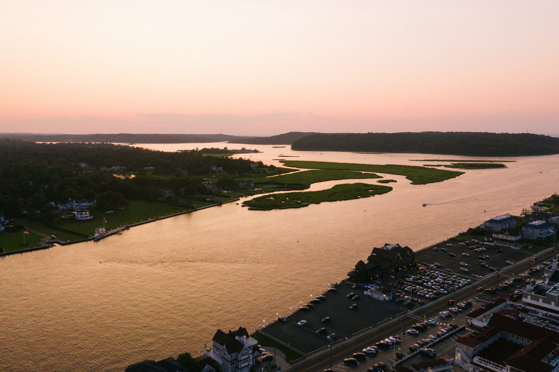 Aerial sunset view over the Navesink River and bay near Windows on the Water with pink and orange sky, Sea Bright NJ