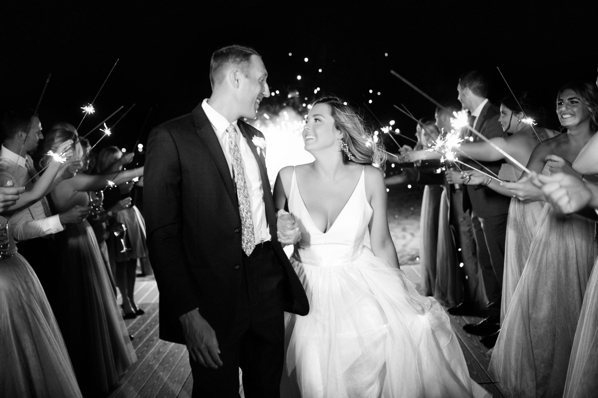 Close-up of couple during sparkler exit looking at each other and smiling at Windows on the Water wedding, Sea Bright NJ, black and white