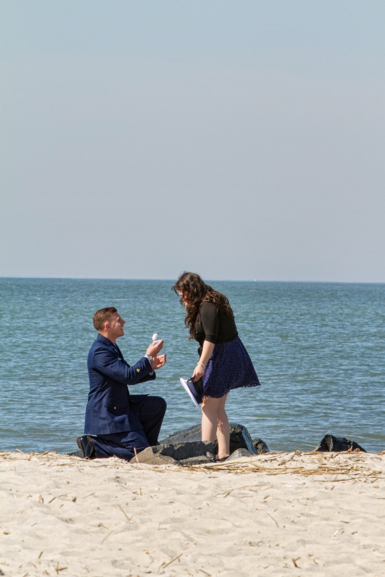 Wes proposing to Sarah on the Cove Beach jetty in Cape May at sunset