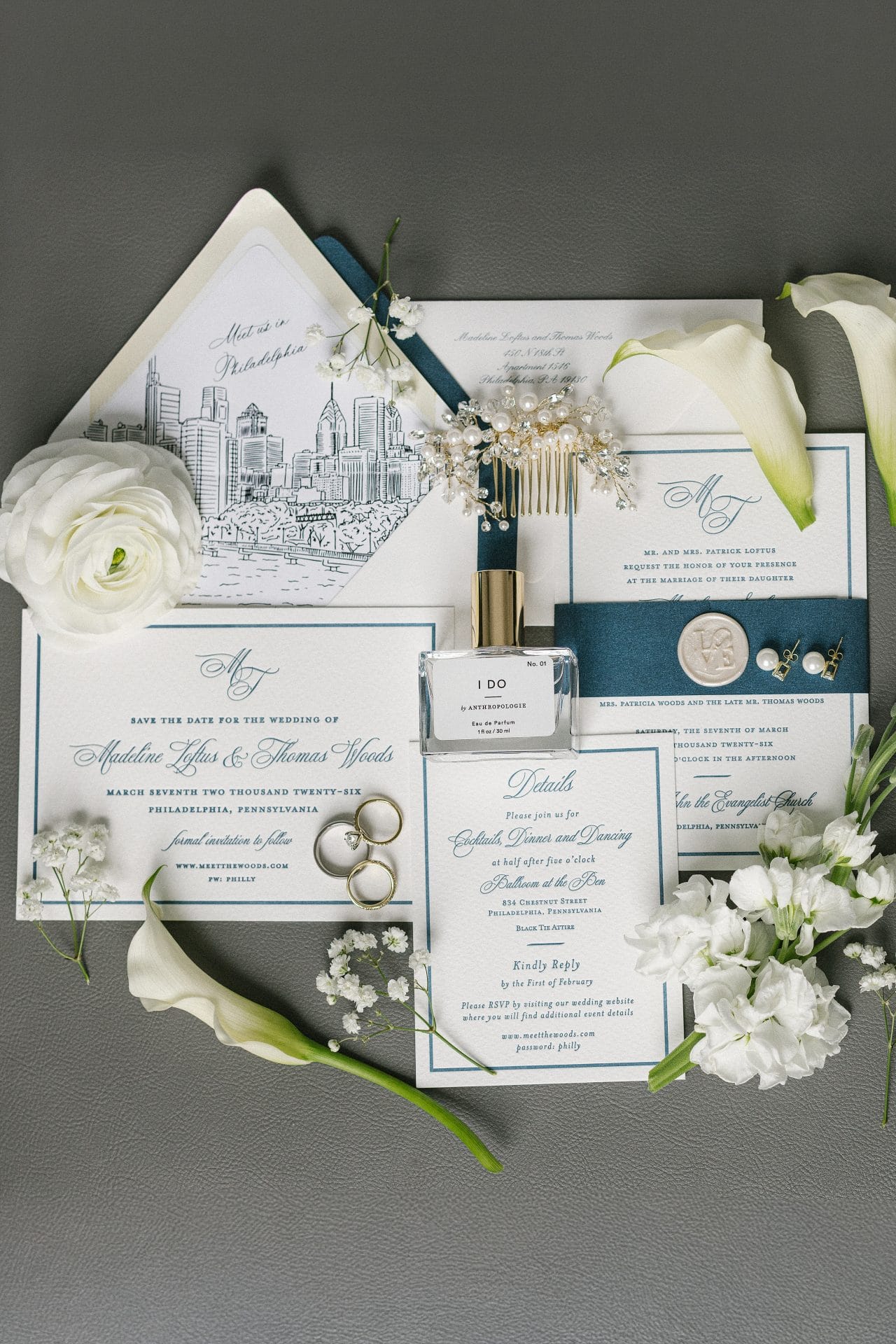 Wedding invitation flat lay with rings calla lily bouquet and bridal details
