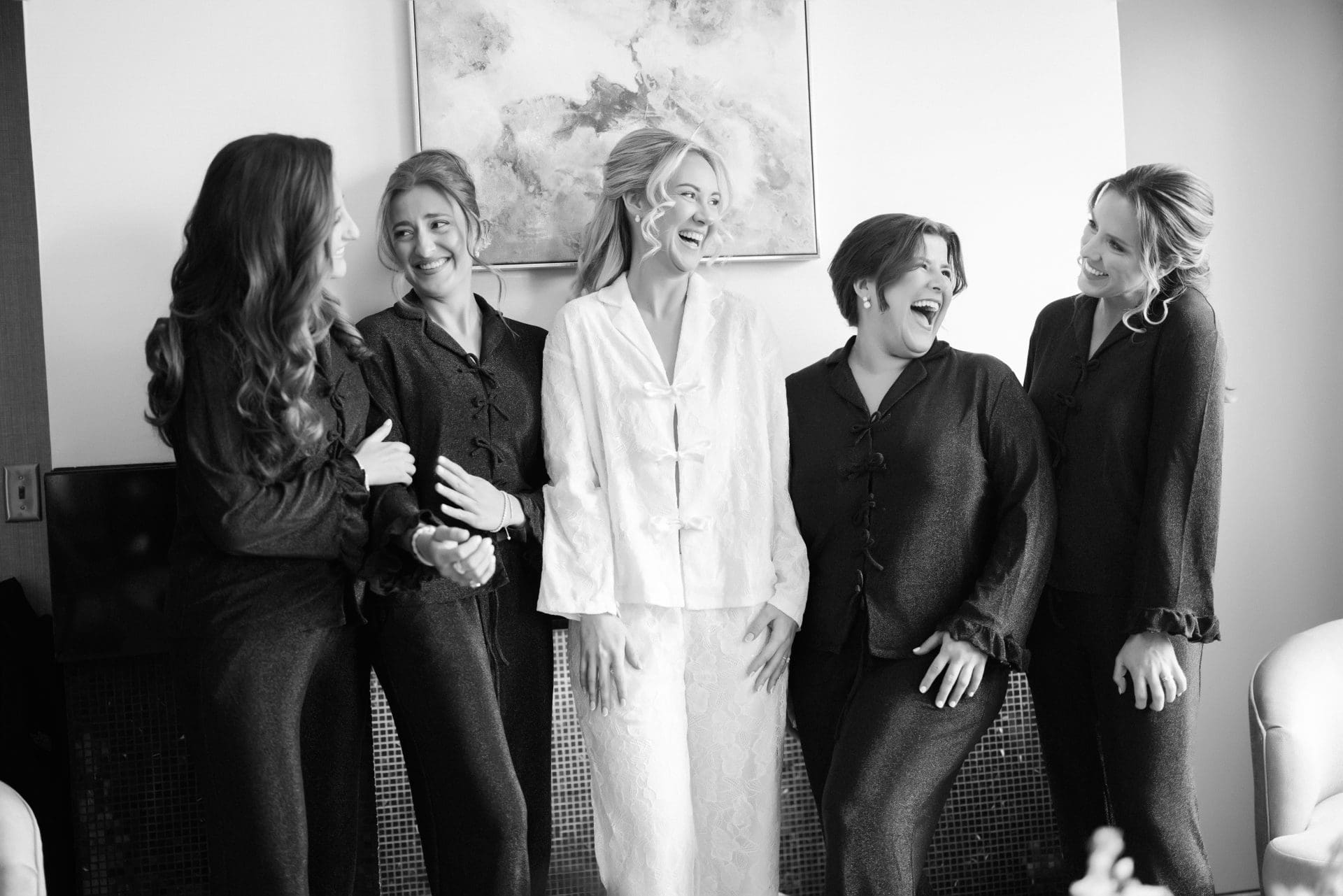 Bride and bridesmaids laughing in matching pajamas at Loews Hotel Philadelphia