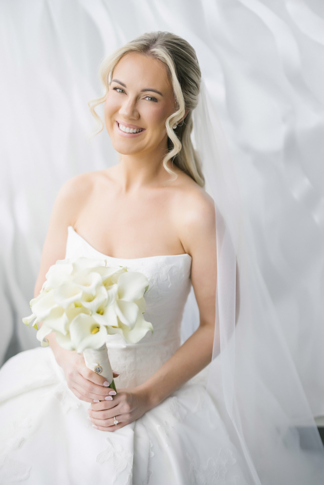 Bridal portrait with white calla lily bouquet and cathedral veil at Loews Hotel