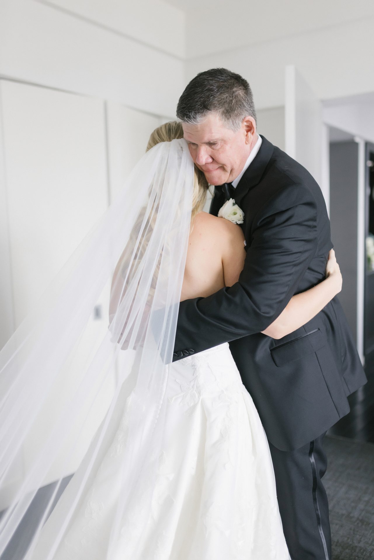 Dad hugging bride showing full wedding dress train at President Suite Loews Hotel